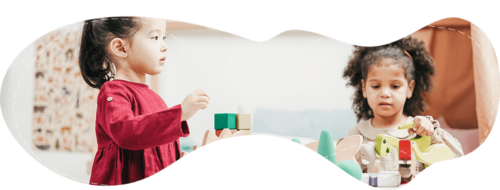 two girls playing together with wooden toys