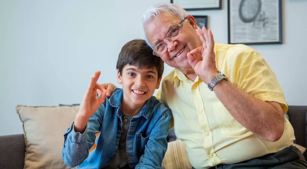 Kind en grootvader ondertekenen 'ok' in handtaal