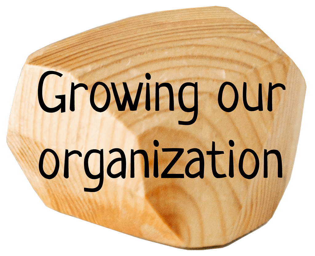 Cale en bois avec texte "Growing our organisation"