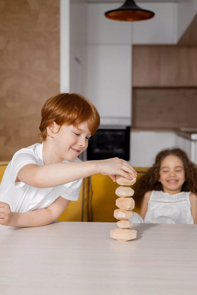 Children stacking wooden blocks on top of each other