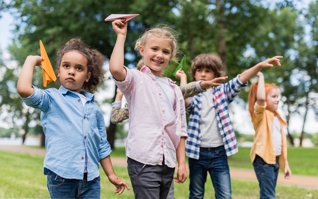 Bambini che tengono in mano i loro aeroplani di carta